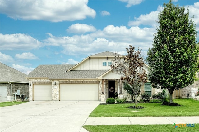 view of front of home with an attached garage, stone siding, concrete driveway, a front yard, and board and batten siding