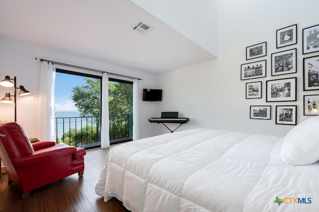 bedroom with access to exterior, wood finished floors, and visible vents