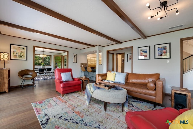 living room with visible vents, stairs, beam ceiling, an inviting chandelier, and wood finished floors