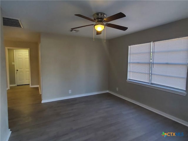 spare room featuring ceiling fan and dark wood-type flooring