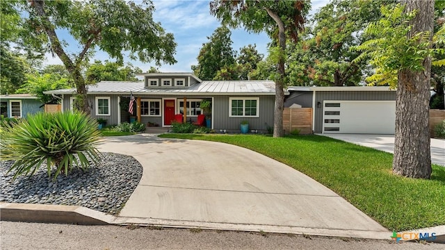 view of front of property with a porch, concrete driveway, an attached garage, metal roof, and a front lawn