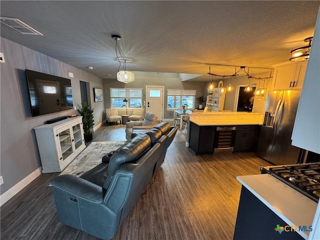 living room featuring a textured ceiling, dark wood-type flooring, and a chandelier