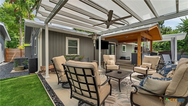 view of patio featuring a ceiling fan, fence, and an outdoor living space