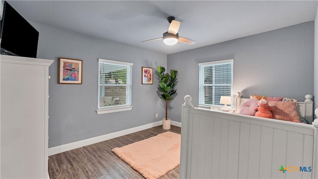 bedroom with wood finished floors, a ceiling fan, and baseboards