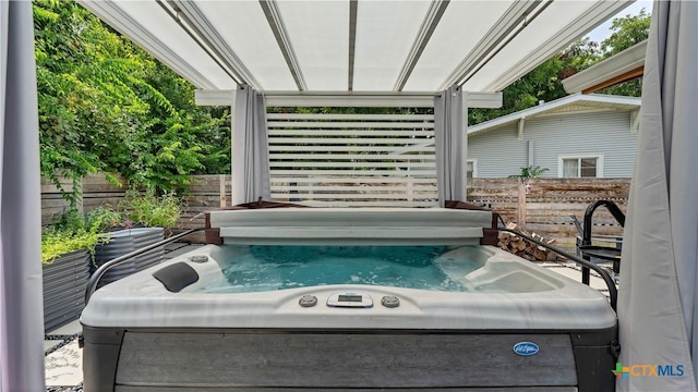 view of patio / terrace featuring a hot tub and fence