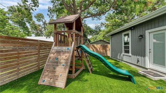 view of play area with fence and a yard