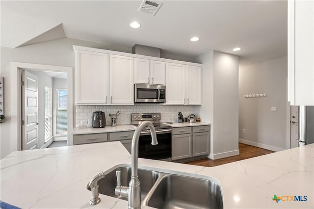 4001 Crockett Ave, Lago Vista, TX 78645 - kitchen with stainless steel appliances, tasteful backsplash, baseboards, white cabinetry, and recessed lighting