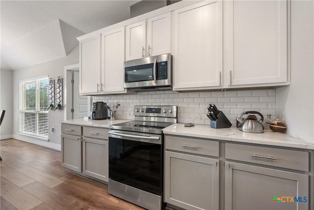 4001 Crockett Ave, Lago Vista, TX 78645 - kitchen with stainless steel appliances, gray cabinets, decorative backsplash, and baseboards