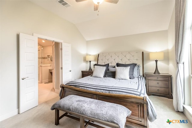 bedroom featuring lofted ceiling, light carpet, visible vents, a ceiling fan, and ensuite bath