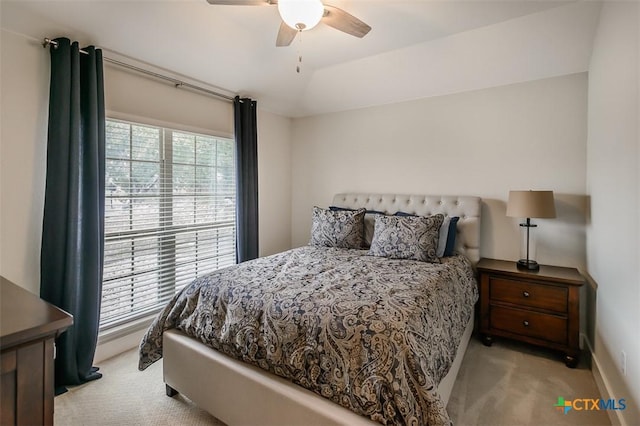 bedroom with light carpet, vaulted ceiling, and a ceiling fan