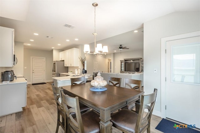 dining area featuring lofted ceiling, recessed lighting, ceiling fan with notable chandelier, visible vents, and light wood-style floors