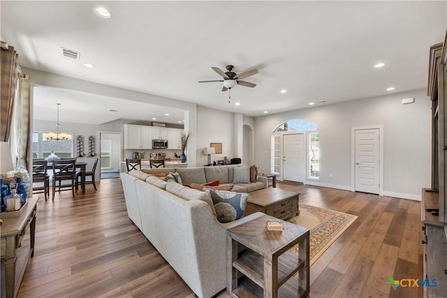 4001 Crockett Ave, Lago Vista, TX 78645 - living room featuring ceiling fan, arched walkways, hardwood / wood-style floors, recessed lighting, and a chandelier