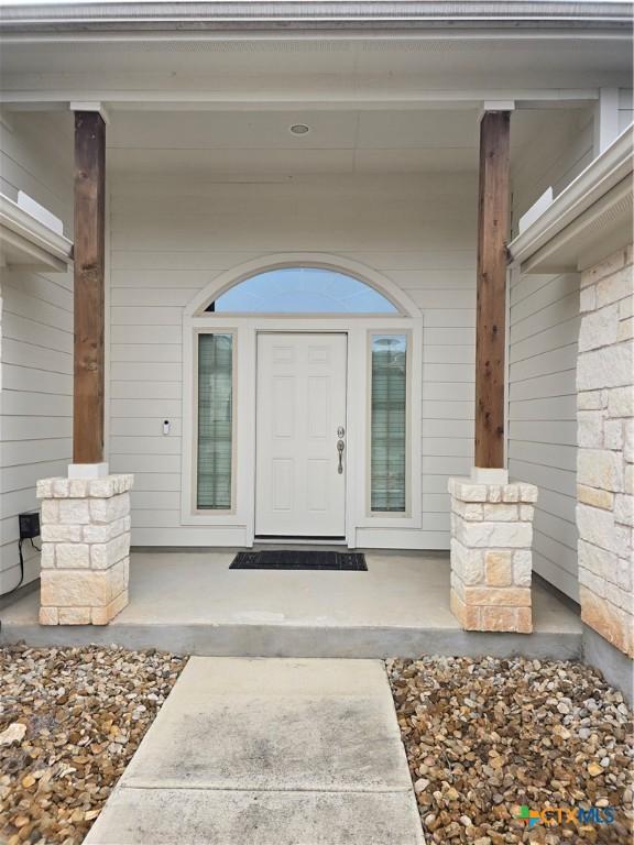 view of exterior entry featuring a porch