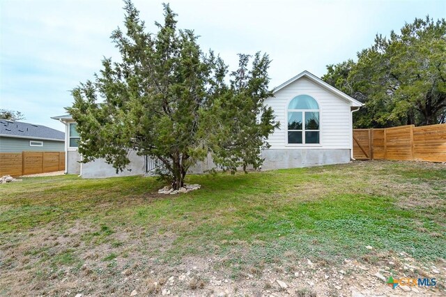 exterior space with a fenced backyard and a lawn