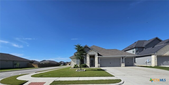 134 Nathaniel Dr, Taylor, TX 76574 - view of front of home featuring a garage, concrete driveway, a front yard, and stone siding