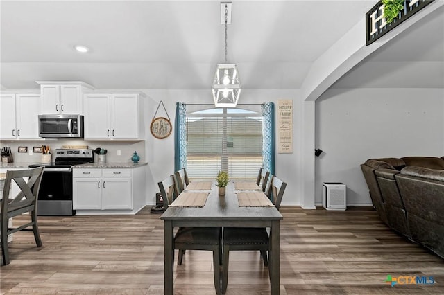 dining area with light wood-style flooring, baseboards, and recessed lighting