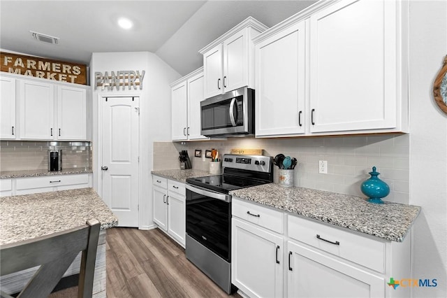 kitchen featuring white cabinetry, appliances with stainless steel finishes, visible vents, and backsplash