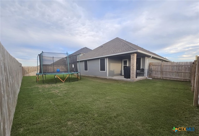134 Nathaniel Dr, Taylor, TX 76574 - rear view of house with a trampoline, a patio, and roof with shingles