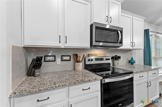 kitchen with white cabinetry, decorative backsplash, light stone counters, and appliances with stainless steel finishes