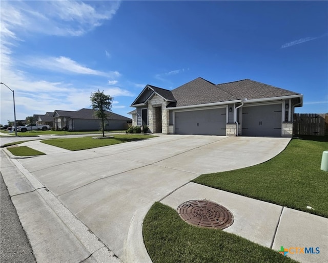 134 Nathaniel Dr, Taylor, TX 76574 - view of front of house featuring driveway, a garage, stone siding, and roof with shingles