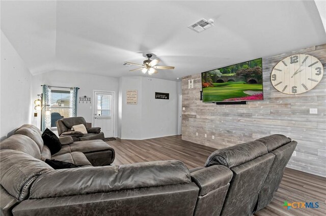 living area featuring wood finished floors, visible vents, an accent wall, ceiling fan, and baseboards