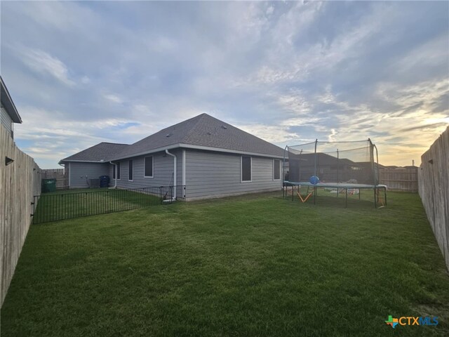 134 Nathaniel Dr, Taylor, TX 76574 - back of house featuring a trampoline and a shingled roof