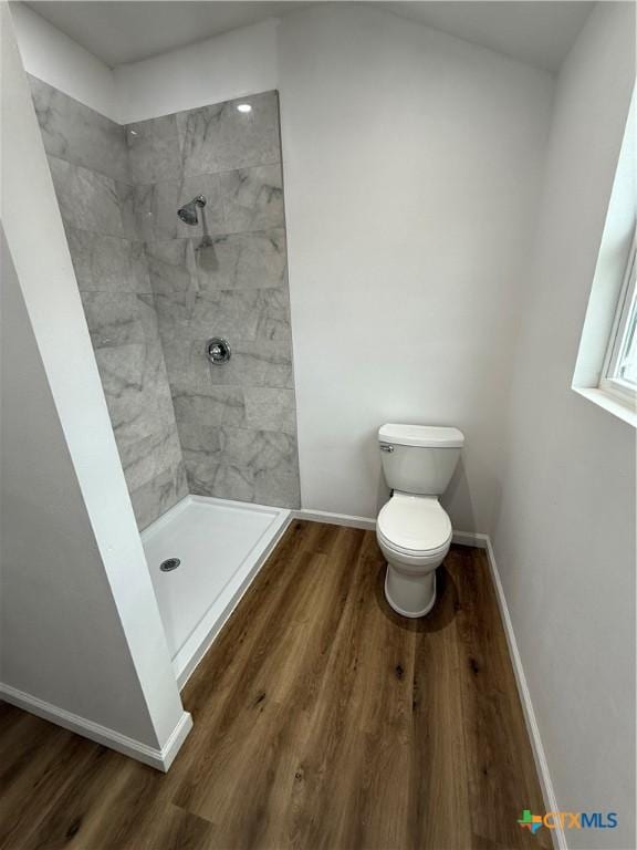1907 Falconwood Dr, San Marcos, TX 78666 - bathroom with a tile shower, toilet, wood finished floors, and baseboards
