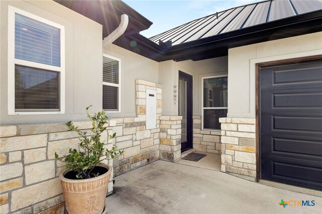 1125 Provence Pl, New Braunfels, TX 78132 - view of exterior entry featuring a standing seam roof, stone siding, metal roof, and stucco siding