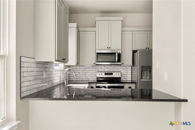 1125 Provence Pl, New Braunfels, TX 78132 - kitchen featuring appliances with stainless steel finishes, a peninsula, backsplash, and a sink