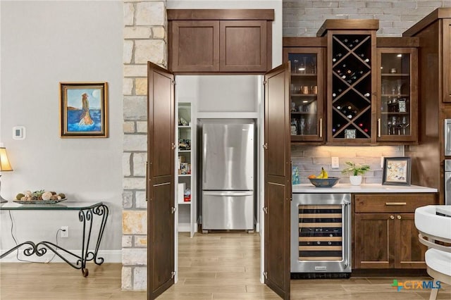 1125 Provence Pl, New Braunfels, TX 78132 - indoor bar featuring stainless steel appliances, wine cooler, light wood-type flooring, tasteful backsplash, and baseboards