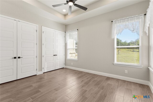 1125 Provence Pl, New Braunfels, TX 78132 - unfurnished bedroom with two closets, multiple windows, baseboards, and recessed lighting
