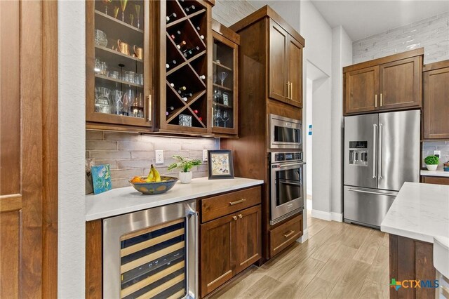 1125 Provence Pl, New Braunfels, TX 78132 - bar with stainless steel appliances, wine cooler, tasteful backsplash, light wood-type flooring, and baseboards
