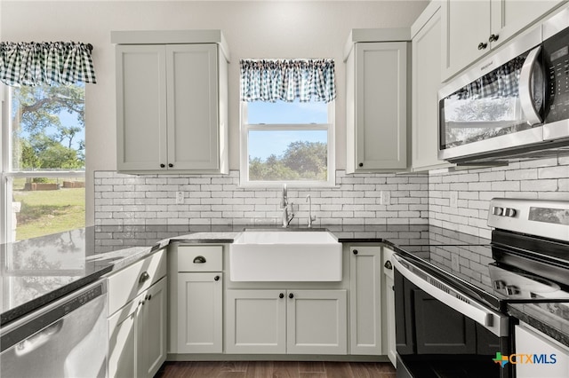 1125 Provence Pl, New Braunfels, TX 78132 - kitchen with appliances with stainless steel finishes, a sink, backsplash, and dark stone countertops