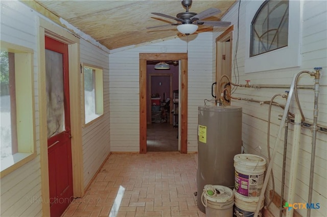 132 Madrona Ln, Bandera, TX 78003 - hallway with water heater, brick patterned flooring, wood walls, and vaulted ceiling