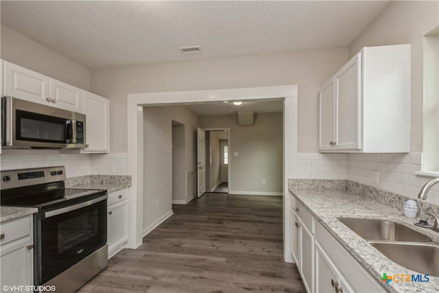 kitchen featuring white cabinets, sink, dark wood-type flooring, and appliances with stainless steel finishes