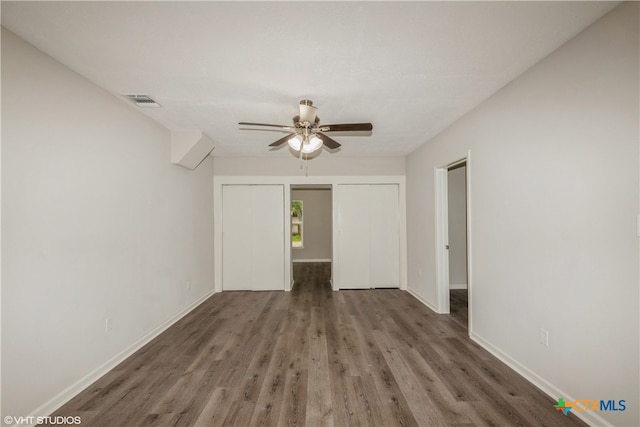 spare room with dark wood-type flooring and ceiling fan