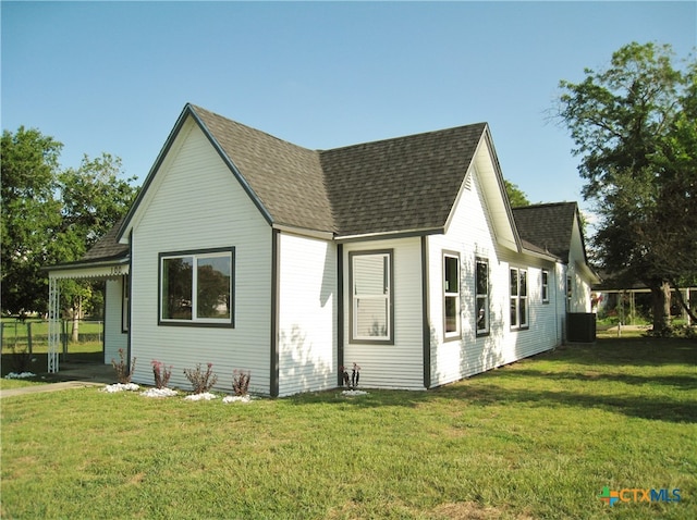 view of home's exterior featuring central air condition unit and a yard