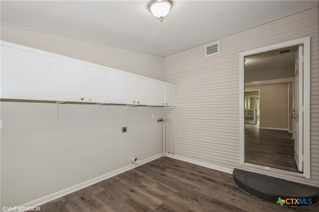 laundry area featuring hookup for an electric dryer, cabinets, and dark hardwood / wood-style floors