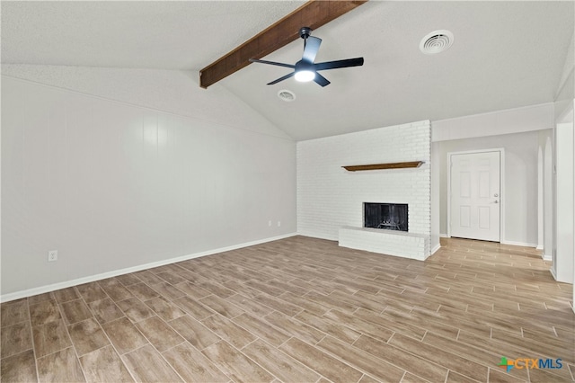 unfurnished living room featuring ceiling fan, a textured ceiling, a fireplace, light wood-type flooring, and lofted ceiling with beams