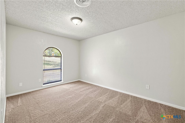 spare room with a textured ceiling and carpet floors