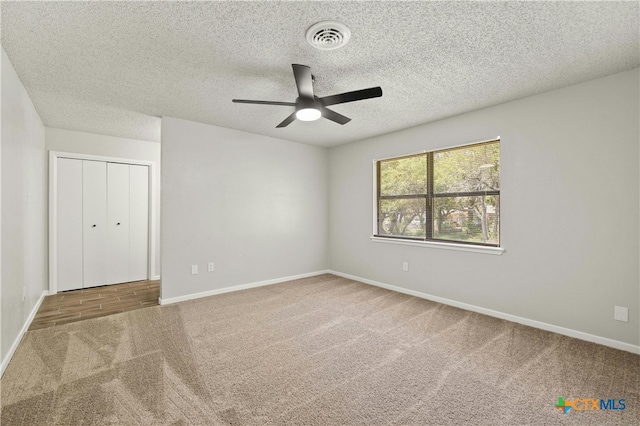 carpeted empty room with a textured ceiling and ceiling fan