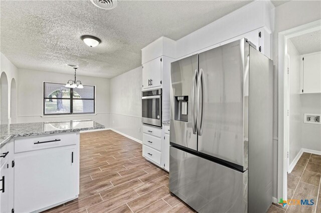 spare room with hardwood / wood-style floors and a textured ceiling