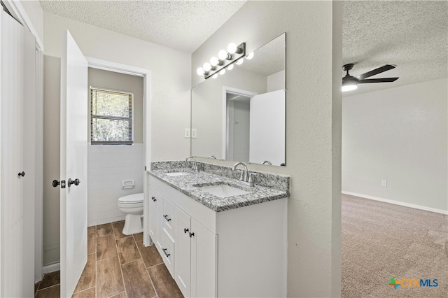 bathroom with vanity, a textured ceiling, hardwood / wood-style floors, toilet, and ceiling fan