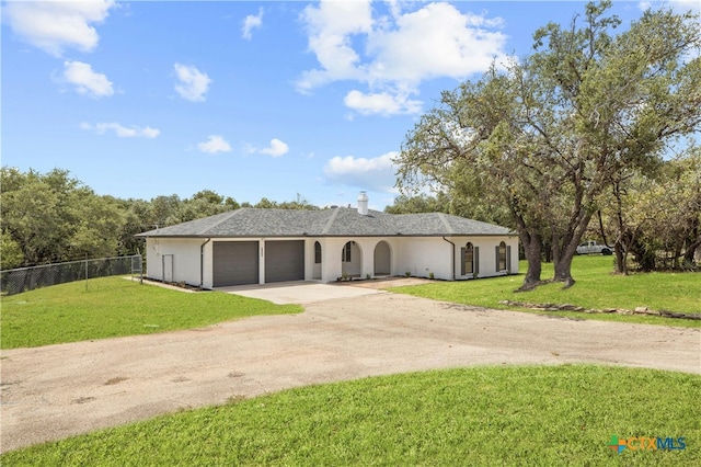 single story home with a garage and a front yard