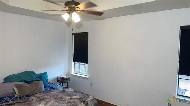bedroom featuring a ceiling fan, wood finished floors, and baseboards