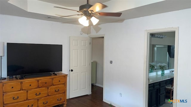 bedroom with visible vents, baseboards, dark wood-style flooring, a ceiling fan, and ensuite bath