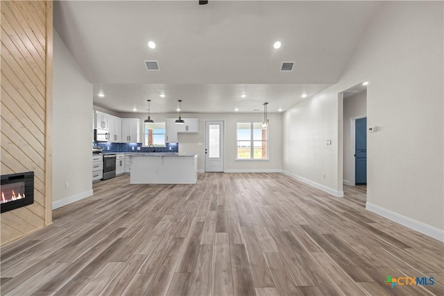1811 Ember Dr, Temple, TX 76502 - unfurnished living room with light wood finished floors, vaulted ceiling, a tile fireplace, and recessed lighting