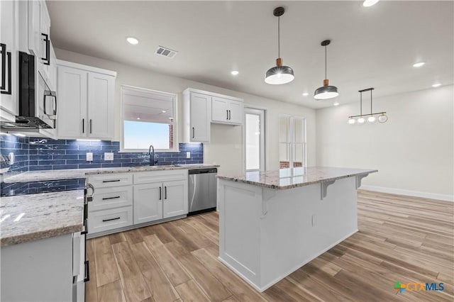 1811 Ember Dr, Temple, TX 76502 - kitchen featuring stainless steel appliances, decorative backsplash, light wood-style flooring, white cabinetry, and recessed lighting