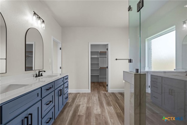 1811 Ember Dr, Temple, TX 76502 - bathroom featuring double vanity, wood finished floors, and a walk in closet