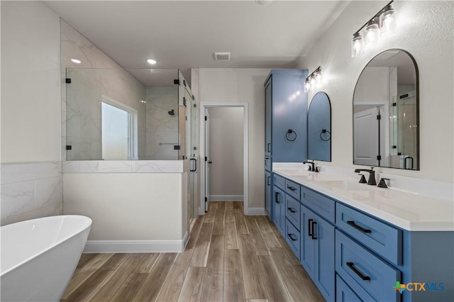 1811 Ember Dr, Temple, TX 76502 - full bathroom with a stall shower, double vanity, a soaking tub, wood finished floors, and recessed lighting